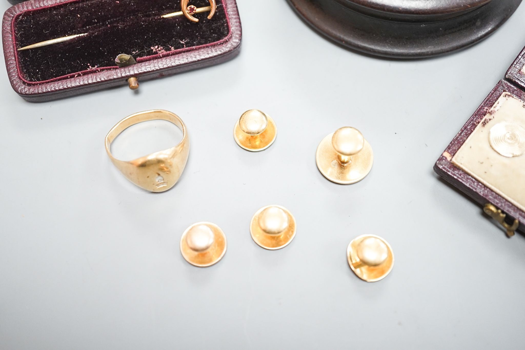 A yellow metal signet ring(a.f.) 7.1 grams, four assorted yellow metal dress studs stamped 18, 7 grams, one other stud stamped 15, 1.2 grams, a 9ct and gem set stick pin, gross 0.6 grams and six cased yellow metal studs.